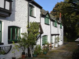 uma fila de casas brancas com persianas verdes em The Clochfaen em Llangurig