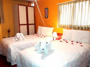 two beds with stuffed elephants on them in a hotel room at Ayma Hostel Puno in Puno