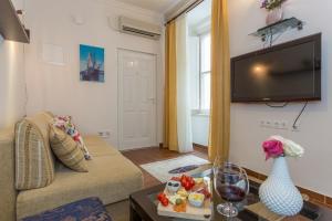 a living room with a couch and a tv at Apartment and Rooms Stay in Dubrovnik