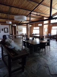 Habitación grande con mesas y sillas de madera. en Paralelo 42° Lodge, en El Maitén