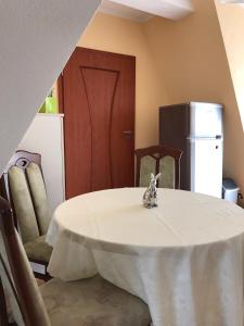 cocina con mesa, sillas y nevera en Apartament Onyx en Międzyzdroje