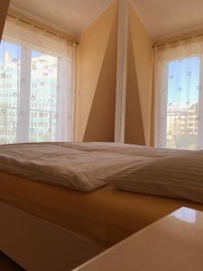 Cama en habitación con 2 ventanas en Apartament Onyx en Międzyzdroje