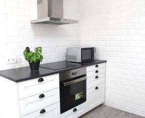 a kitchen with a black counter top and a microwave at Origens Hostel in Sines