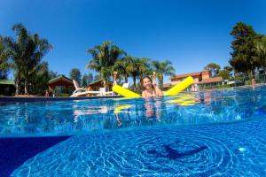 Eine Frau liegt im Wasser in einem Pool. in der Unterkunft BIG4 Moruya Heads Easts Dolphin Beach Holiday Park in Moruya