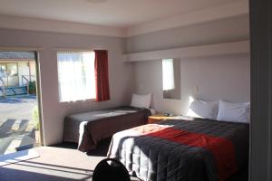 Un pat sau paturi într-o cameră la Coronation Court Motel
