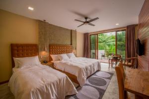 a bedroom with two beds and a large window at Kiha Beach in Dharavandhoo