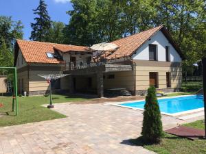 una casa con un aro de baloncesto y una piscina en Családi Villa, en Balatonszemes