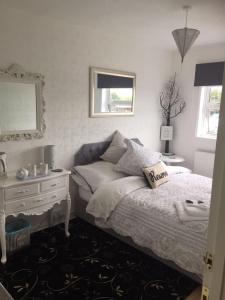 a bedroom with a bed and a table and a mirror at Southend Airport Bed & Breakfast in Rochford