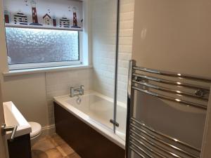 Un baño con bañera, inodoro y lavabo. en Exmouth holiday home, en Exmouth 12 fotos más