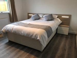 Una cama grande en un dormitorio con suelo de madera. en Exmouth holiday home, en Exmouth