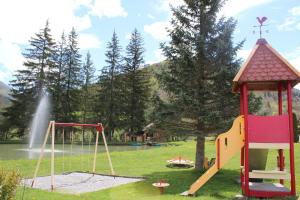a playground with a slide and a swing set at La Neyrette in Saint-Disdier-en-Dévoluy