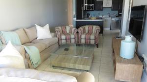 a living room with a couch and chairs and a table at Summerseas 58 in Port Elizabeth