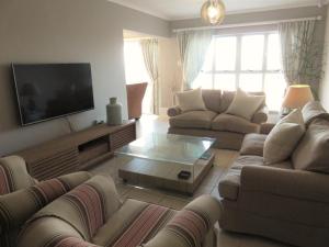 a living room with couches and a flat screen tv at Summerseas 58 in Port Elizabeth