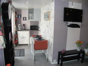 a small kitchen with a small table and a small room at Studio Callanya in Callantsoog