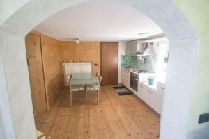 a kitchen with an archway and a table in a kitchen at Ca' Nei Ronchi Bregaglia in Piuro