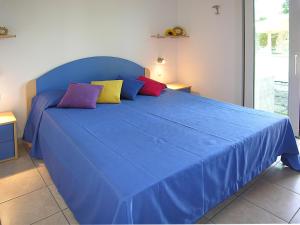 ビビオーネにあるAppartamenti Casa Del Mareのベッドルームに青いベッド1台(カラフルな枕付)