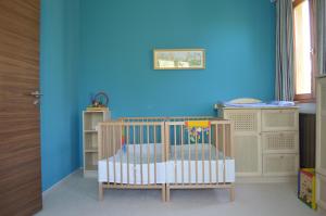 Pokój z łóżeczkiem dziecięcym i niebieską ścianą w obiekcie Villa - ZMRD w Zamárdi