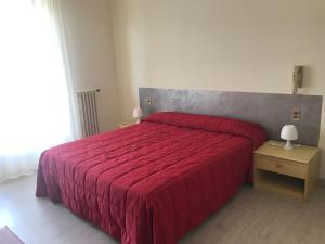 1 dormitorio con cama roja y edredón rojo en Albergo Bar Ristorante Alla Rama en Malcesine