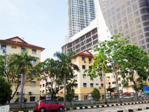 a red van parked in front of a building with tall buildings at G2 Holiday Apartment in Melaka