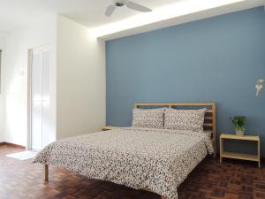 a bedroom with a bed and a blue wall at G2 Holiday Apartment in Melaka