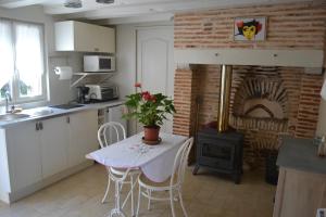 a kitchen with a table and a stove at La Licorne in Lamarche-sur-Saône
