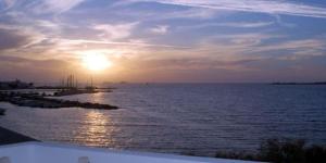 a sunset over a large body of water at Hotel Paros in Parikia