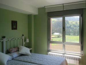 a bedroom with a bed and a window with a view at Apartamentos Arcos del Esva in Luarca