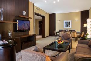 a living room with a couch and a tv at TIME Oak Hotel & Suites in Dubai