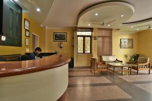 un homme assis au bar dans une salle d'attente dans l'établissement Hotel Galaxy, à Dehradun