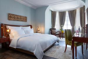 a bedroom with a large bed and a large window at Carmella Boutique Hotel in Haifa
