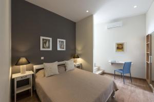 a bedroom with a bed and a desk and a chair at Mythos Residence in Rethymno