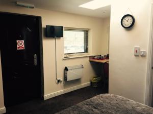 a room with a bed and a clock on the wall at Market in Elsecar