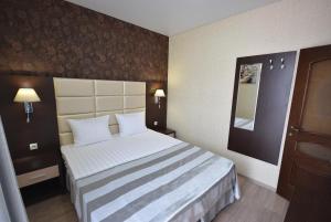 カバルジンカにあるVilla Deluxe Kedrovayaの大きなベッドと鏡が備わるホテルルームです。