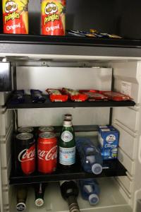 a refrigerator filled with drinks and cans of soda at Kirketon Hotel Sydney in Sydney