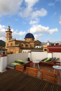 a rooftop with chairs and tables and a building at Casa Grimalt in Jalón