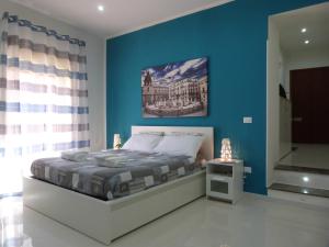 パレルモにあるCasa Principe Maquedaの青い壁のベッドルーム1室、ベッド1台が備わります。
