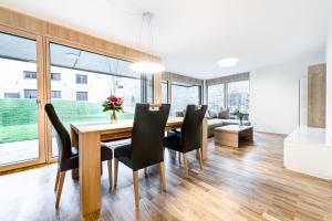 a dining room with a wooden table and black chairs at Gartenappartment de Luxe by A-Appartments in Brand