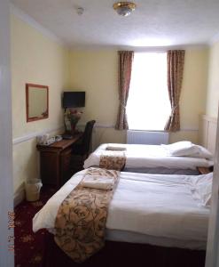 
A bed or beds in a room at Arden Guest House
