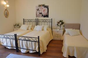 Casa Eleganza في تريميزو: غرفة نوم بسريرين وطاولة مع ورد