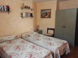 Un dormitorio con 2 camas y una silla. en Appartamento Villa Edera, en Baja Sardinia