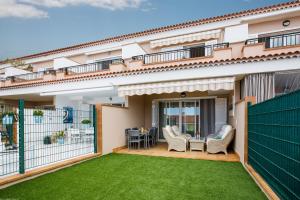a balcony with a lawn in front of a house at Residencial Playa de La Arena in Puerto de Santiago