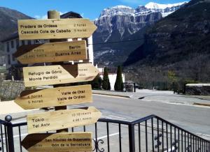 a sign with arrows pointing in different directions at Edelweiss Hotel in Torla-Ordesa