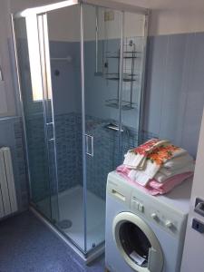 a bathroom with a washing machine and a glass shower at Casa San Paolo in Sarnico