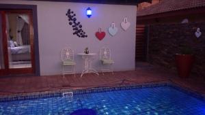 a house with a table and chairs next to a pool at Dinaledi House in Bela-Bela