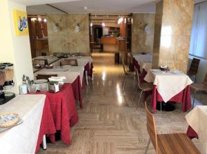 un restaurante con mesas con manteles rojos. en Hotel Città Studi, en Milán