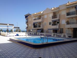 a building with a swimming pool in front of a building at Apartamento a 100m de la playa in Torrevieja