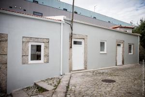 een wit gebouw met een witte deur en een straat bij Ilha da Glória - Miragaia in Porto