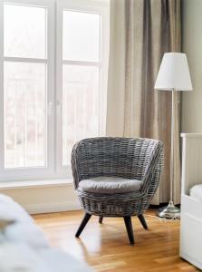 una silla de ratán en una sala de estar con lámpara en Domizil Gols, Boutique - Hotel en Gols