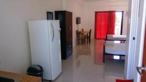 a kitchen with a white refrigerator in a room at The Palines Apartment and Guesthouse - Vista Alabang in Manila