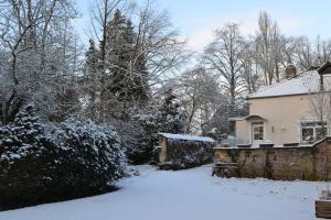 ein schneebedeckter Hof neben einem Haus in der Unterkunft La Licorne in Lamarche-sur-Saône